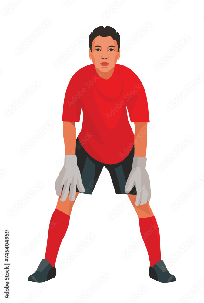 Asian teenage goalkeeper of junior football teem in red uniform and gloves who stands upright in goal and waits for the ball