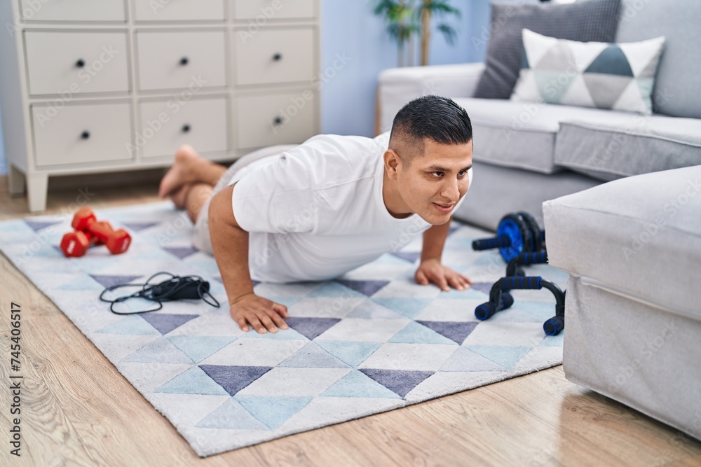 Young latin man smiling confident training push up at home Young latin man smiling confident training push up at home