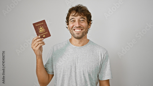 Cheerful young man joyfully flashing his philippine passport, standing confidently isolated against a pure white background photo