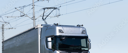 Electric semi truck with pantograph takes energy from wires above the highway
