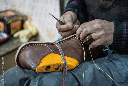 Closeup of artisan handcrafting brown leather shoe