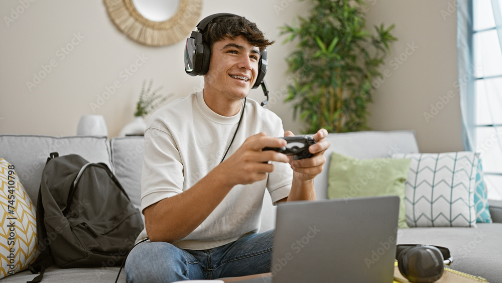 Φωτογραφία Cheerful, young hispanic teenager student, gamepad in hand, engrossed in online gaming, lounging on living room sofa, making his apartment a lively gaming house