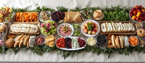 A table adorned with an extensive variety of foods such as snacks, canapés, sandwiches, and fresh veggies. The display is suitable for occasions like birthdays, corporate events, or weddings. photo
