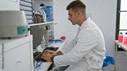 Young, handsome hispanic scientist engrossed in intensive medical research, using computer analysis in a professional lab environment