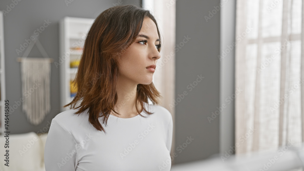 Young hispanic woman with a thoughtful expression in a bright, modern bedroom interior, conveying a sense of beauty and tranquility. Young hispanic woman with a thoughtful expression in a bright, modern bedroom interior, conveying a sense of beauty and tranquility.