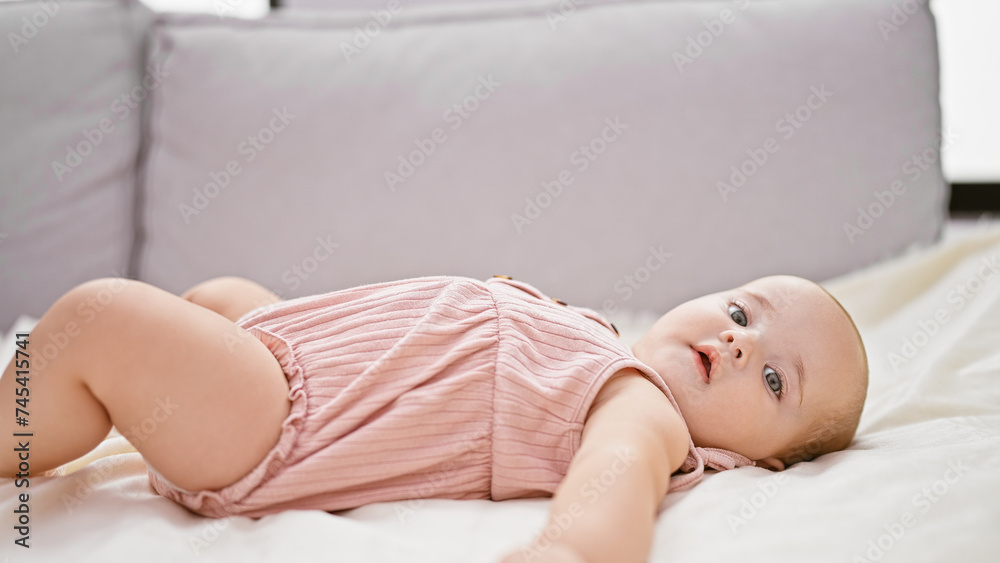 Adorable newborn baby girl, caucasian, blissfully relaxed lying on a comfortable sofa, swaddled in a blanket at her welcoming home, capturing the essence of innocent infant lifestyle indoors Adorable newborn baby girl, caucasian, blissfully relaxed lying on a comfortable sofa, swaddled in a blanket at her welcoming home, capturing the essence of innocent infant lifestyle indoors