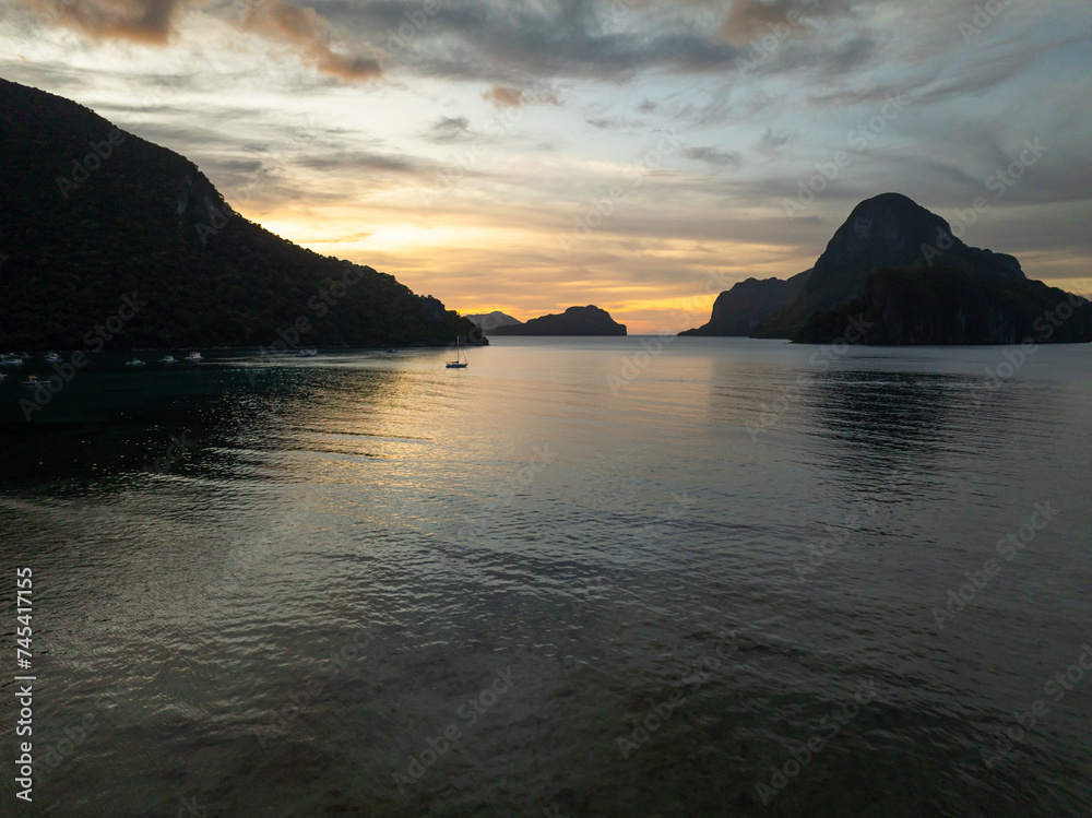 Scenic landscape of sunset reflection on sea water. Cloudy sunset in El Nido. Palawan, Philippines.