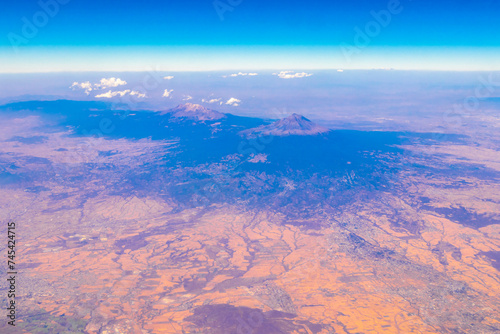 Flying airplane over Mexico Clouds Sky Volcanoes Mountains City desert.