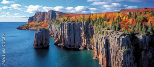 This picture showcases a large body of water, Lake Superior, glistening under the sunlight, while being surrounded by a dense forest of green trees. photo