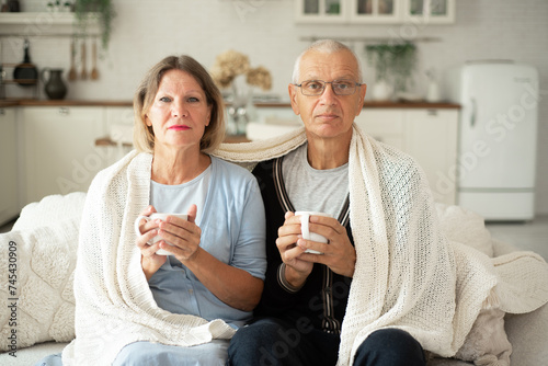 Portrait of a couple with cups of tea in their hands.
