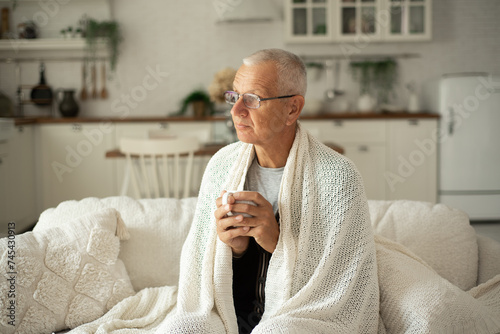 An elderly man is freezing in his apartment in winter.