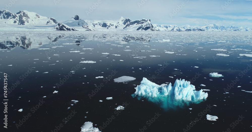 Obraz premium Melting iceberg drift in open Antarctica ocean. Arctic winter landscape at global warming problem. Polar climate change at sunny winter day. Cinematic ecology scene. Aerial drone flight