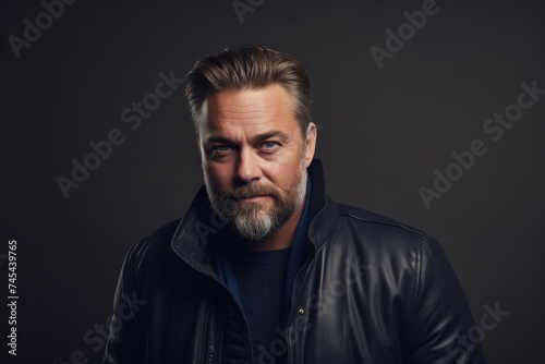 Portrait of a serious mature man in a black leather jacket. © Asier