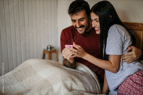 A couple holding hands and rejoicing over a positive pregnancy test