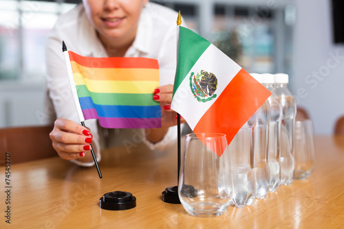Secretary shows the flags of Mexico and LGBT on the table. Preparing for a meeting, negotiations. photo