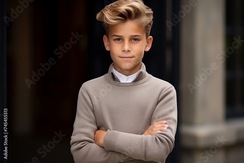 Portrait of a handsome young boy with blond hair in a sweater.