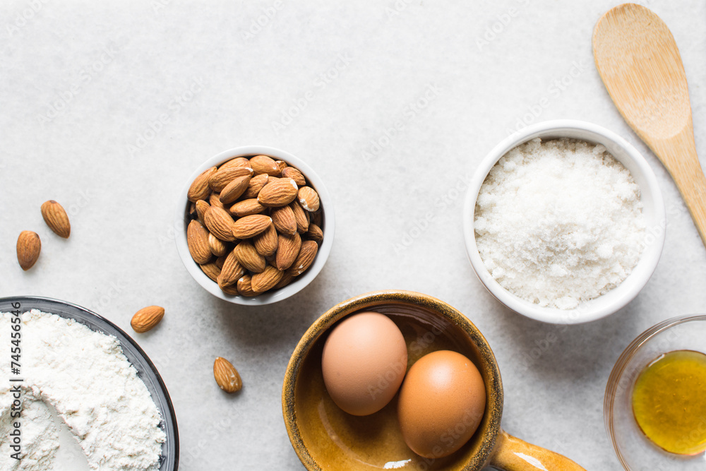 overhead view of mise en place for almond biscotti dough, ingredients for making almond cantucci cookie on a marble countertop overhead view of mise en place for almond biscotti dough, ingredients for making almond cantucci cookie on a marble countertop