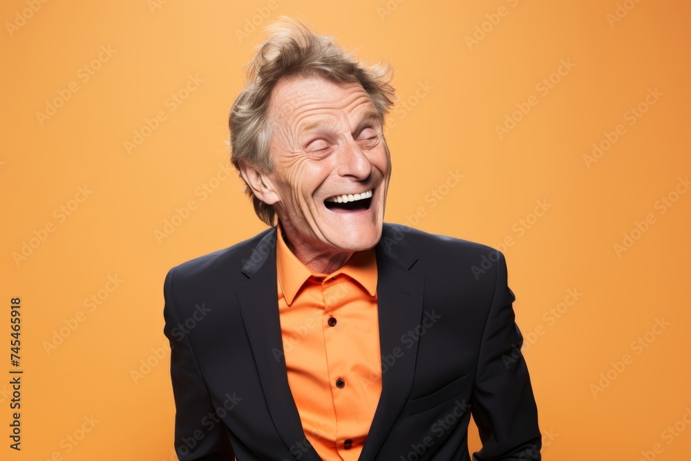 Portrait of happy senior man laughing and looking at camera over orange background Portrait of happy senior man laughing and looking at camera over orange background