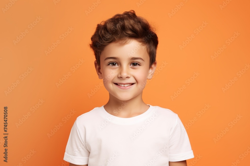 Portrait of a cute smiling little boy in a white t-shirt on an orange background Portrait of a cute smiling little boy in a white t-shirt on an orange background