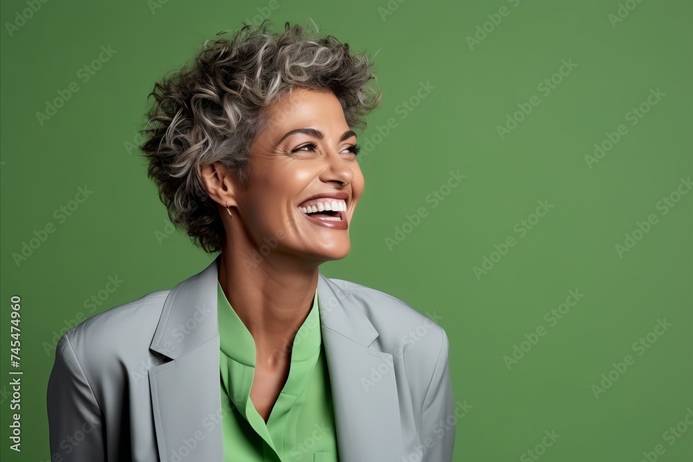 Portrait of a smiling middle-aged businesswoman in a suit on a green background Portrait of a smiling middle-aged businesswoman in a suit on a green background