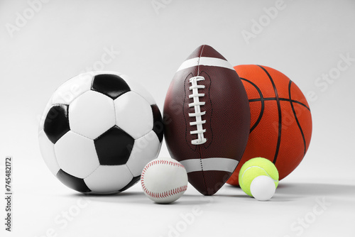 Many different sports balls on light gray background