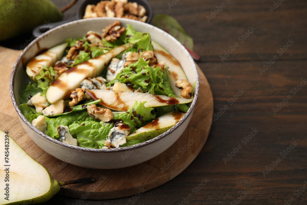 Delicious pear salad with sauce in bowl on wooden table, closeup. Space for text Delicious pear salad with sauce in bowl on wooden table, closeup. Space for text
