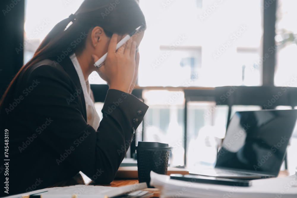 Asian women are stressed while working on laptop, Tired asian businesswoman with headache at office, feeling sick at work, copy space Asian women are stressed while working on laptop, Tired asian businesswoman with headache at office, feeling sick at work, copy space
