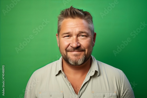 Portrait of a happy mature man looking at camera over green background