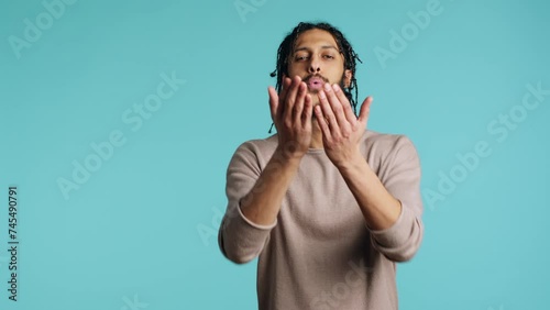 middle eastern frisky playful man blowing kisses to camera, being flirty. Lively charming BIPOC person having fun sending air kisses, doing romantic gesturing, studio background, camera A photo