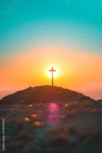 A sunset with a cross on a tall hill in a blue sky sunrise, and installation-based art.