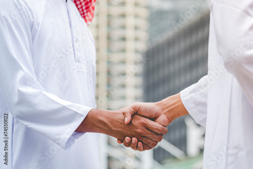 Bilde på lerret Islamic businessman shake hands together dealing success business in modern muslim UAE city