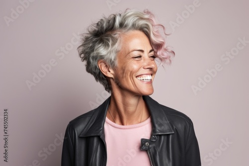 Portrait of a happy senior woman with pink hair and white smile. © Inigo