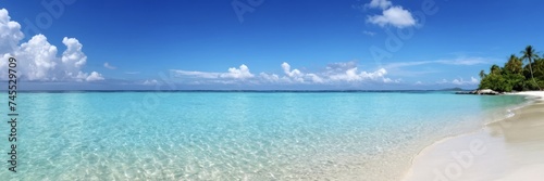 Tropical beach with white sand and crystal clear turquoise water in sea. Vibrant blue sky with small clouds © orelphoto
