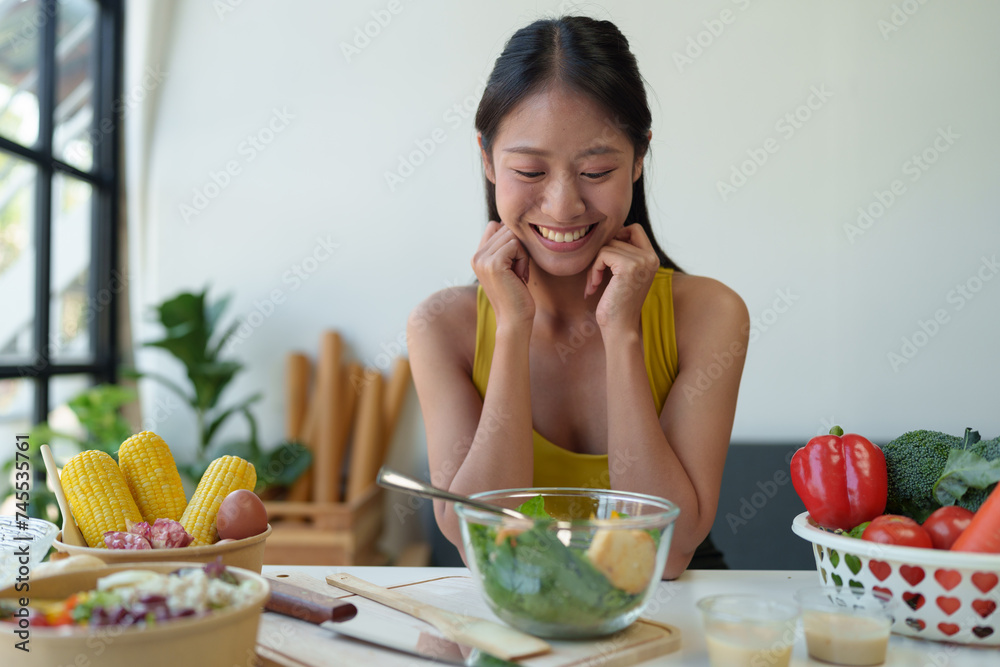 Beautiful young woman in exercise clothes preparing vegetable salad in the kitchen, healthy food Vegetarian salads, ideas, fasting, food selection, healthy lifestyle, cooking at home. Beautiful young woman in exercise clothes preparing vegetable salad in the kitchen, healthy food Vegetarian salads, ideas, fasting, food selection, healthy lifestyle, cooking at home.