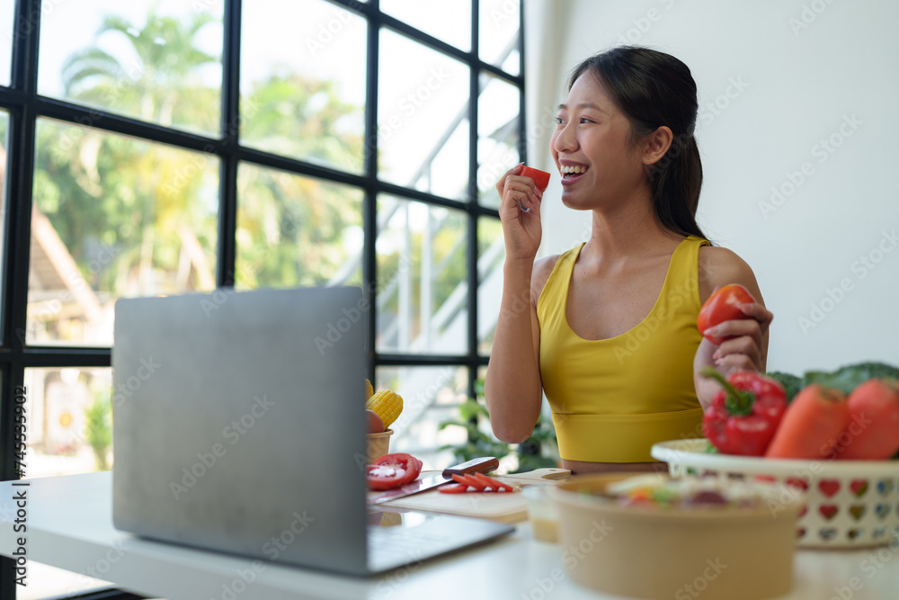Beautiful young woman in exercise clothes preparing vegetable salad in the kitchen, healthy food Vegetarian salads, ideas, fasting, food selection, healthy lifestyle, cooking at home.