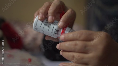 Nurse hands put Vitamin A supplement capsule in to plastic packaging. Close up selective focus photo