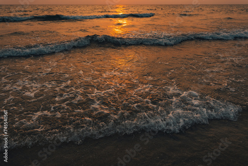 Sunset on the beach,Golden sea waves at sunset photo