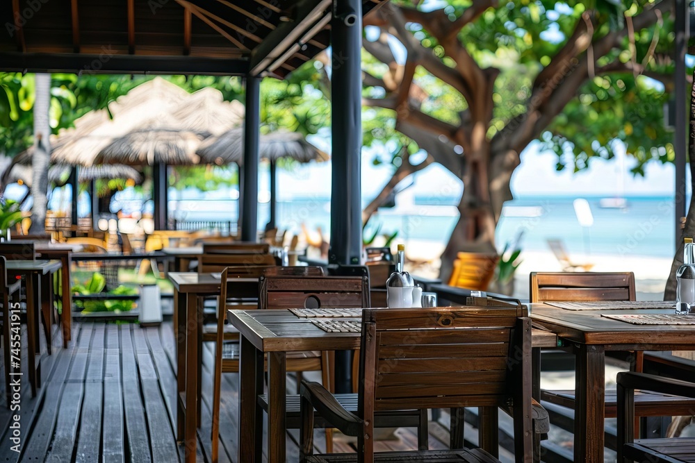 Caf terrace with wooden tables and chairs Providing a cozy outdoor setting for dining Against a backdrop of a blurred beach scene.