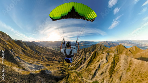 Extreme paraglider pilot flying over New Zealand mountains, adventure concept. photo