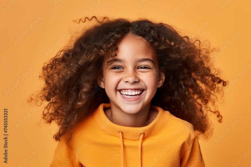 Portrait of happy little african american girl with curly hair, isolated on yellow background Portrait of happy little african american girl with curly hair, isolated on yellow background