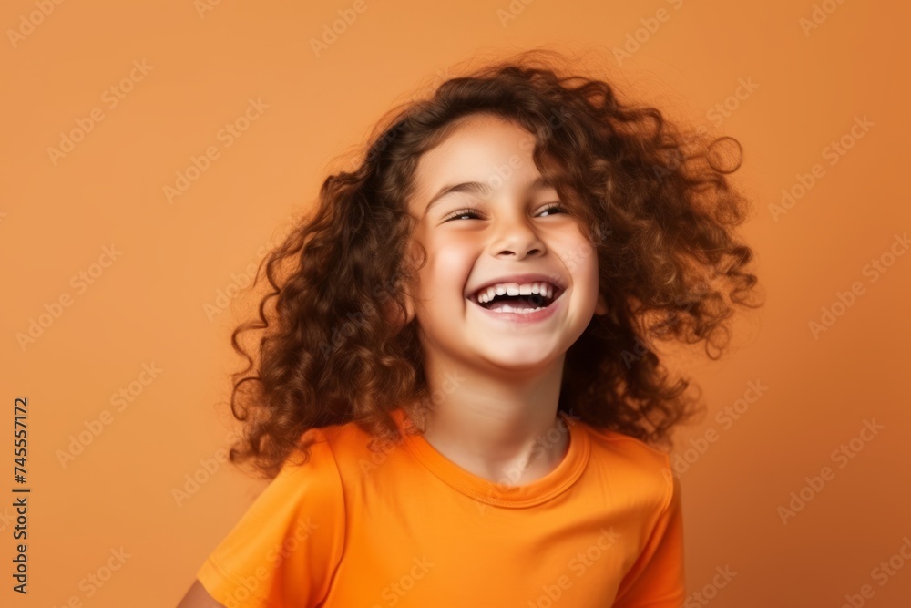 Portrait of a happy little girl with curly hair over orange background Portrait of a happy little girl with curly hair over orange background