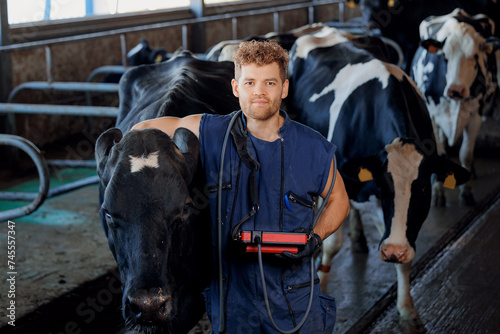 Veterinarian man with ultrasound device hugs cow pregnant on farm. Concept love to animals and health care for cattle, artificial insemination