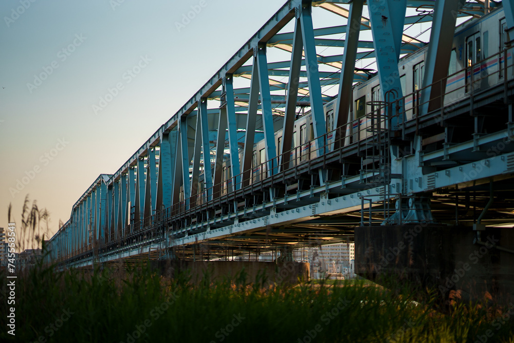 Train running on the railway bridge in the evening | 夕方の電車