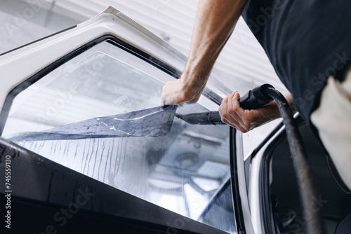 Process remove protective vinyl tint film from car. Transparent protection for window vs sun photo