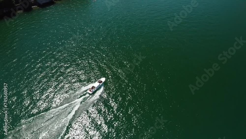Speedboat cruising on Lake Como with lush surroundings, aerial view photo