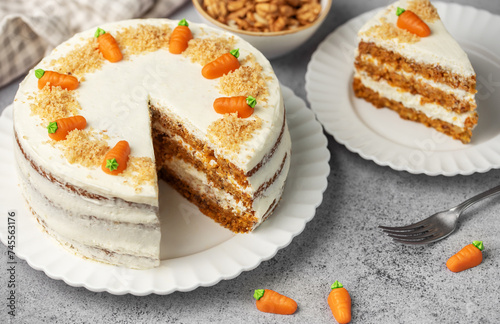 Homemade carrot cake made with walnuts, iced with cream cheese. Sweet dessert.