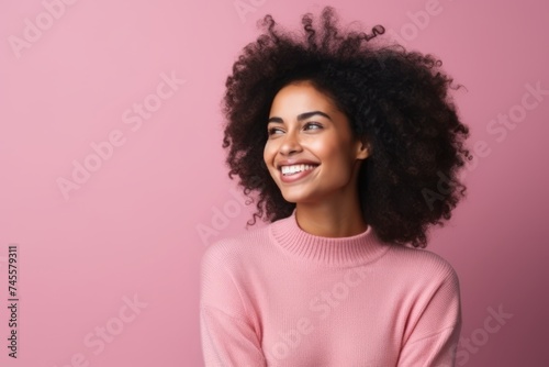 Portrait of a beautiful young african american woman smiling against pink background