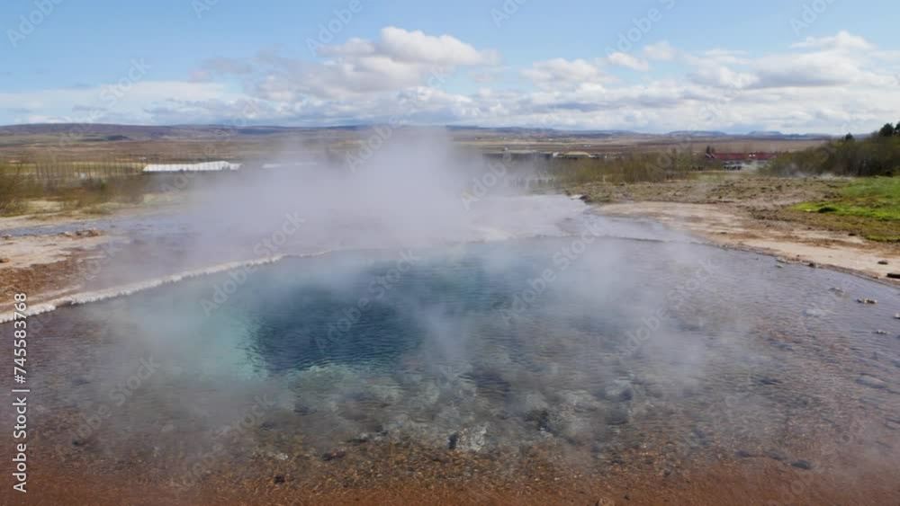Steaming blue hot spring in Haukadalur Valley in South Iceland, Wide low shot Steaming blue hot spring in Haukadalur Valley in South Iceland, Wide low shot