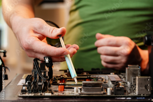 Man applies thermal paste to the CPU photo
