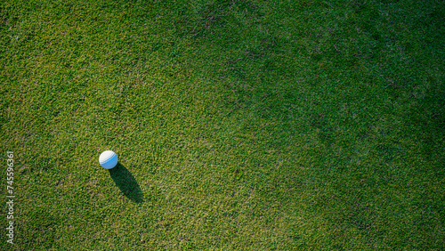 Golf ball on green grass in the evening golf course with sunshine background.